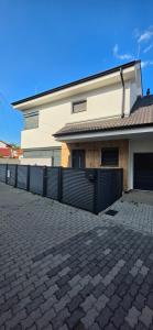 a house with a fence and a brick driveway at Vila Castrum in Nové Zámky