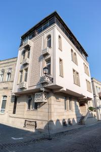 a large white building with balconies on a street at Gala Terrace Hotel & Restaurant in Baku