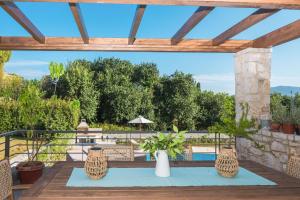 a patio with a table and chairs and trees at Azure Villa Kanoni in Análipsis