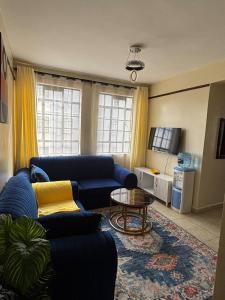 a living room with a blue couch and a table at Prestige apartments Machakos in Machakos