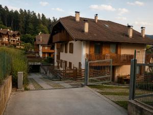 a house with a fence in front of it at APPARTAMENTO ROEN - Val di Non in Cavareno