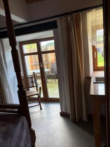 a bedroom with a door open to a porch with a chair at Agroturystyka Muraszkowa Zagroda in Giebułtów