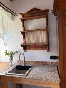 a kitchen with a sink and a wooden cabinet at Agroturystyka Muraszkowa Zagroda in Giebułtów