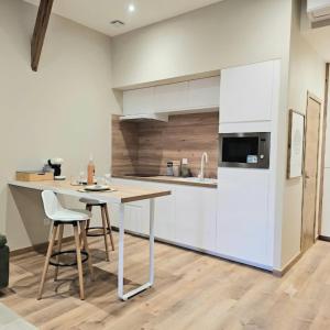 a kitchen with a table and a white refrigerator at Le 3Bis studio charmant proche Cap d'Agde in Bessan