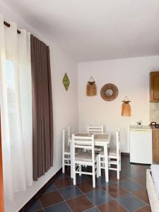 a kitchen and dining room with a table and chairs at N'Gjaci Guest House in Tale
