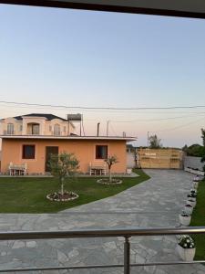 a house with two trees in the front yard at N'Gjaci Guest House in Tale