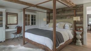 a bedroom with a canopy bed and a bathroom at The Inn at GrayBarns in Norwalk