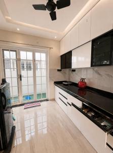 a kitchen with white cabinets and a black counter top at Bougain Villa in Nashik
