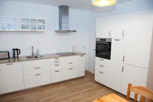a white kitchen with white cabinets and appliances at Apartament Joanna in Szczedrzyk