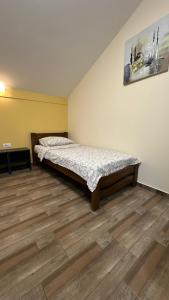 a bedroom with a bed and a wooden floor at Apartmani Kovačević MKM Banja Vrujci in Gunjica