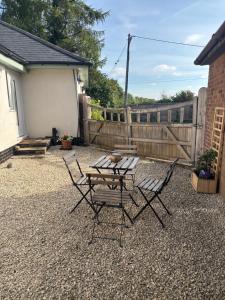 a patio with a table and chairs and a fence at Boycott House in Shalstone
