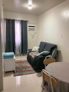 a living room with a couch and a table at Linear Space at Soleia Butuan Unit G in Butuan