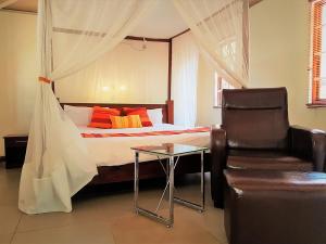 a bedroom with a bed with a chair and a table at Mara Son Camp in Maasai Mara National Reserve