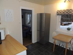 a kitchen with a stainless steel refrigerator and a table at Tindelykke in Isfjorden