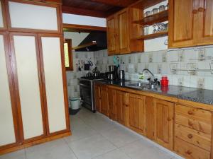 a kitchen with wooden cabinets and a counter top at Casa Malen Llao Llao in San Carlos de Bariloche