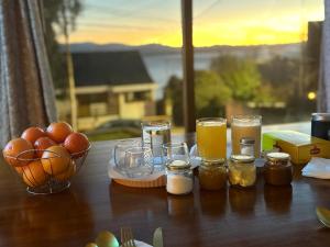 a table with jars of honey and a bowl of fruit at Olly Patagonia Suites in San Carlos de Bariloche