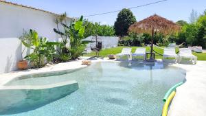 a swimming pool with white chairs in a backyard at Villa Aura, Kanalia Corfu in Corfu