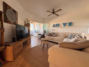 a living room with a couch and a flat screen tv at Albir Adventino LOVE in Albir