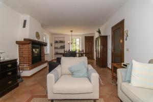 a living room with two chairs and a fireplace at Villa Supina - 3BDR with Pool & Panoramic Lake Garda Views in Toscolano Maderno