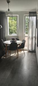 a dining room with a table and chairs and a window at Apartament w centrum in Biskupiec