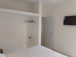 a bedroom with a bed and a flat screen tv at Macao Sky pool Suite in Punta Cana