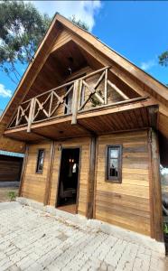 a large wooden house with a gambrel roof at Cabanas Brisa da Lagoa in Arroio do Silva