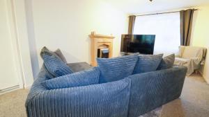 a blue couch with pillows on it in a living room at Whitebeam in Solihull