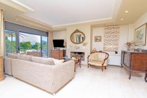 a living room with a couch and a fireplace at Azure Villa Kanoni in Análipsis