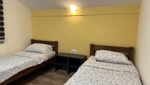 a small room with two beds and a table at Apartmani Kovačević MKM Banja Vrujci in Gunjica