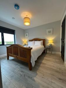 a bedroom with a large bed and a large window at Homestay Wild Atlantic View Binghamstown in Belmullet
