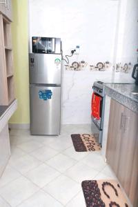 a kitchen with a stainless steel refrigerator and a stove at Bulleys BNB in Thika