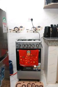 a kitchen with a stove with a red scarf on it at Bulleys BNB in Thika