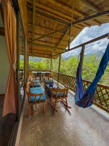 a room with a hammock and chairs on a balcony at Cabaña ALAK in La Vega