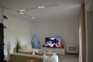a living room with a couch and a tv at Vila 18 in Velipojë