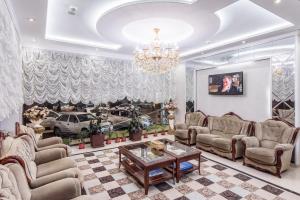 a living room with couches and a chandelier at HUMO Hotel in Stantsiya Kyzyl-Tukumachi