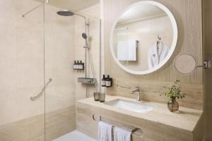 a bathroom with a sink and a mirror at NH Valencia Center in Valencia