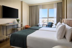 a hotel room with two beds and a television at NH Valencia Center in Valencia