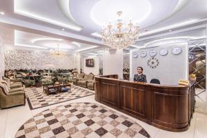 a woman standing behind a bar in a lobby at HUMO Hotel in Stantsiya Kyzyl-Tukumachi