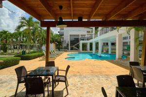 a patio with a table and chairs and a pool at Hideaway in Paradise in Juan Dolio +50 photos