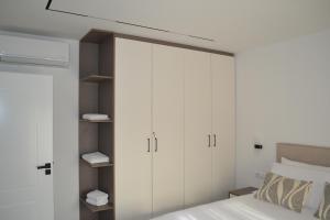 a bedroom with white cabinets and a bed at Vila 18 in Velipojë