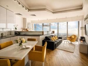 a kitchen and living room with a couch and a table at Apartamenty Sky Tower in Wrocław