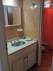 a bathroom with a sink and a mirror and a toilet at Casa Rodas in Goya