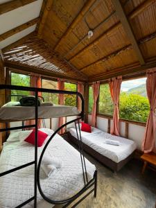 two bunk beds in a room with windows at Cabaña ALAK in La Vega