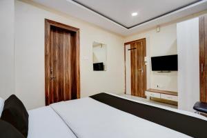 a bedroom with a bed and a flat screen tv at Hotel O Hotel Krishna's Residency in Indore
