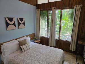 a bedroom with a bed and a large window at casa luca in San José
