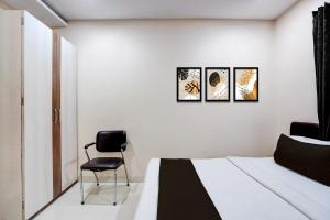 a bedroom with a bed and a chair in it at Hotel O Hotel Krishna's Residency in Indore