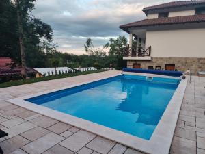 a swimming pool in a yard with a house at Къща за гости ДАЯНИЦА in Kopilovtsi