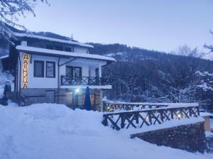 a house in the snow with a bridge in front at Къща за гости ДАЯНИЦА in Kopilovtsi