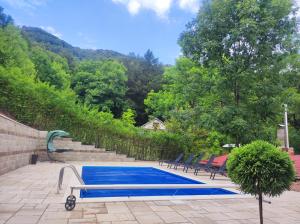 a blue swimming pool in a yard with trees at Къща за гости ДАЯНИЦА in Kopilovtsi +28 photos