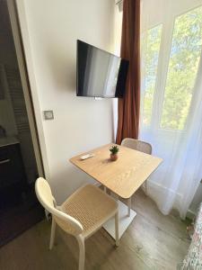 a table with two chairs and a television on a wall at Coudert VI l Petit Studio Climatisé Hyper Centre in Castres